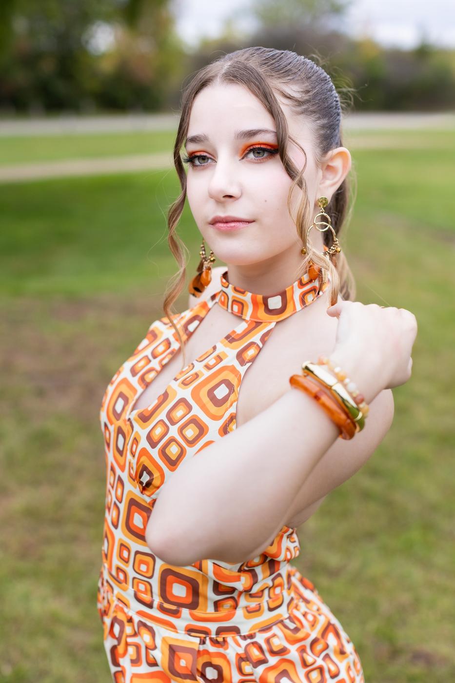 Ariella Sinclair editorial portrait in vintage orange print dress