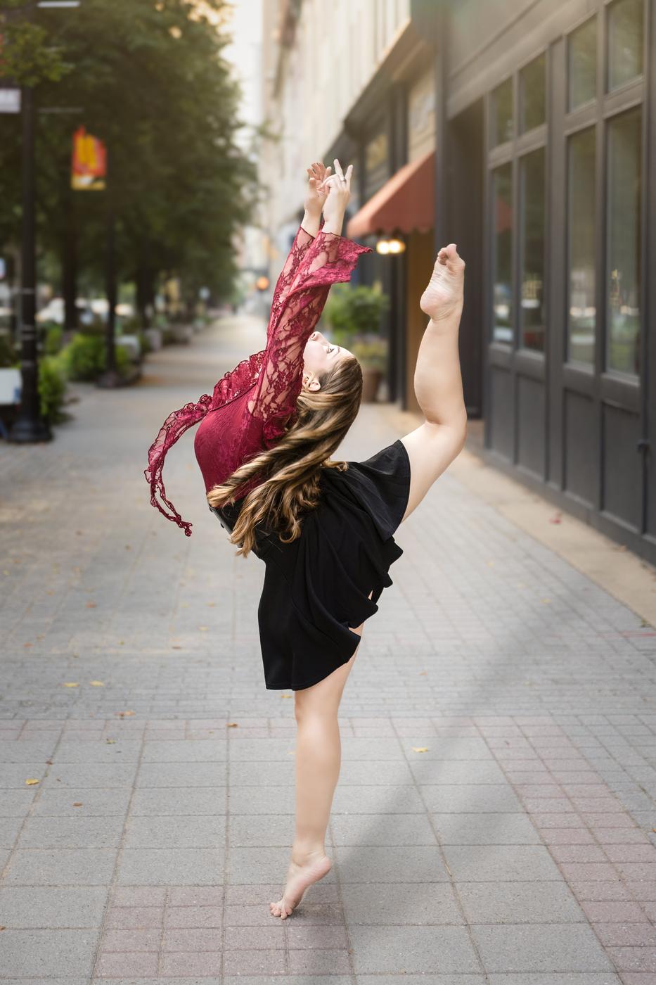 Ariella Sinclair dancing in burgundy lace in an urban street setting