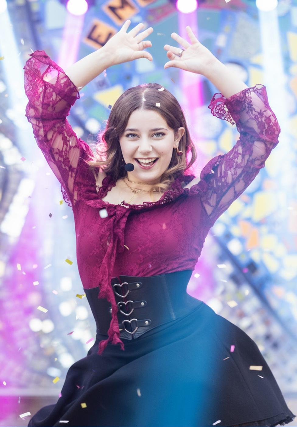 Ariella Sinclair on stage with confetti and stage lights, triumphant moment